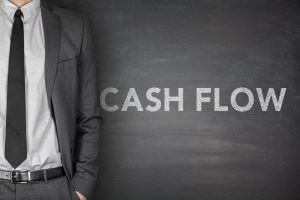 Cash flow on black blackboard with businessman