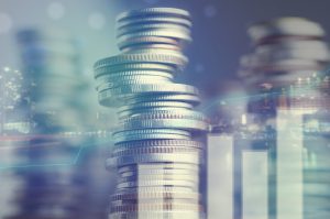 Double exposure of city and graph on rows of coins for finance and banking concept
