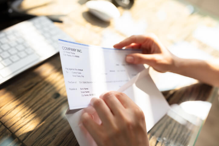 Opening envelope containing paycheck