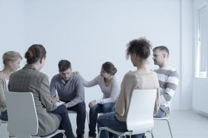 Psychotherapist comforting man with depression during psychotherapy meeting