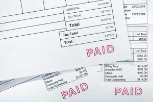 Three Invoices All With Paid Stamp = three invoices for several thousand dollars, all with PAID stamp. These are normal bills, with folds and a few creases.