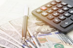 Business, finance, investment, accounting or money exchange concept : American Dollars cash money, calculator on savings account passbook or financial statement