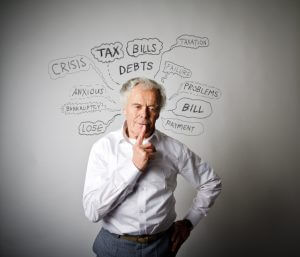 Frustrated old man in white. Taxes, debts and other problems.